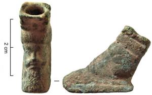PME-4003 - Pied de meublebronzePied de meuble (siège miniature, trépied..?), à tiges obliques,  comportant sur la face externe une tête de Dionysos, de style archaïque.