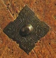 RRL-8006 - Renfort de reliure, bouillon ou boulonbronzeApplique massive, en forme de plaque carrée sur pointes avec au centre une bosse hémisphérique, percée pour une fixation clouée aux angles; contours découpés.