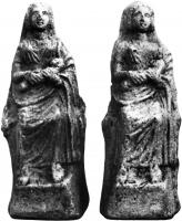 STE-3012 - Statuette : kourotrophosterre cuiteFigurine moulée sur une base quadrangulaire, figurant une déesse assise sur un siège, vêtue d'une longue robe et au visage souriant; elle serre contre elle un nourrisson emmaillotté, tête à gauche.