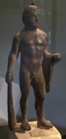 STE-3044 - Statuette : Héraklès - HerculebronzeStatuette représentant Heraklès jeune et athlétique, nu, en position déhanchée vers la droite. Il tient dans la main gauche la massue posée au sol, et la léonté s'enroule autour de l'avant-bras gauche, qui est replié. La main droite tenait quelque chose, sans doute les pommes du Jardin des Hespérides.