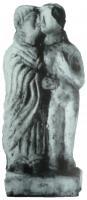 STE-4127 - Statuette : Coupleterre cuiteCouple debout, sur une base quadrangulaire; il comprend une femme  nue, serrée contre un personnage de sexe indéfinissable, drapé dans un long vêtement recouvrant les bras et les jambes jusqu'au sol; les visages se touchent.
