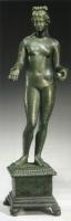 STE-4223 - Statuette : AphroditebronzeStatuette en bronze représentant Aphrodite debout, nue, coiffée d'un chignon transversal au-dessus de la tête; la déesse tient une pomme dans la main gauche, la main droite est tendue.