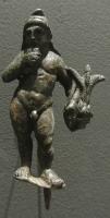 STE-4375 - Statuette : Attisbronzele dieu est figuré sous la forme d'un jeune garçon debout, nu à l'exception de son bonnet phrygien; il tient dans la main gauche les roseaux qui ont servi à fabriquer la flûte de Pan qu'il porte à ses lèvres de la main droite.