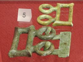 AGC-2028 - Agrafe de ceinture étrusque
bronze
Agrafe composée de deux parties pouvant être reliées par deux forts crochets ouverts : une plaque rectangulaire, rivetée à une extrémité de la ceinture, et portants les autres crochets; en face, deux anneaux reliés à un simple care rectangulaire,,ouvert mais très robuste; côtés parfois concaves.