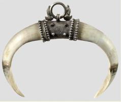 AML-4020 - Pendant à défenses de suidé
dent, argent
Pendant constitué de deux canides inférieuses de suidé (porc ou sanglier), reliée par une double douille surmontée d'un anneau.
