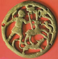 APH-4129 - Phalère de harnais
bronze
TPQ : 150 - TAQ : 250
Applique circulaire, en relief plat et percée de trois trous de fixation  sur le pourtour; le décor ajouré figure un chasseur dans une forêt, plantant sa lance dans un cerf harcelé par deux chiens.