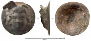 APM-4009 - Applique : tête de Méduse (gorgoneion)
bronze
Applique circulaire, au revers creux mais soit avec une tige (éventuellement arrachée), soit articulée sur une sorte de crampon (passé dans une fente au sommet du motif), soit sans mode de fixation apparent (ni trous sur le pourtour, ni tige de fer centrale), donc probablement prévue pour fixation par brasure sur surface métallique); gorgoneion avec ailettes sur le front et parfois chevelure en serpents.