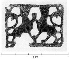 BAC-6039 - Boucle à chape ajourée rivetée : lions affrontés
bronze
Boucle à chape rectangulaire, décor en relief, ajouré et riveté, représentant deux lions affrontés, une patte relevée. La queue redressée forme généralement une boucle en S sur le dos.