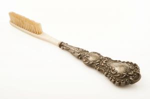 BAD-9003 - Brosse à dents à manche métallique
argent, os, fibres d'origine animale
Brosse à dents composite, l'extrémité distale qui reçoit les touffes de poils, en os, est fixée sur un manche métallique (argent ou autre) orné de reliefs d'inspiration végétale.