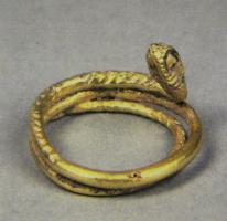 BAG-4034 - Bague serpentiforme
or
TPQ : 1 - TAQ : 300
Bague ouverte, représentant un serpent complet avec sa queue effilée, enroulée sur elle-même. Les écailles apparaissent sous la forme d'incisions croisées.