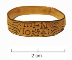 BAG-5091 - Bague rubannée inscriteorTPQ : 600 - TAQ : 700Simple ruban, ouvert, orné de motifs géométrique autour d'un chaton à peine individualisé par un aplatissement ; inscription gravée non rétrograde.