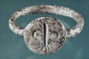 BAG-9064 - Bague avec fleur de lisargentTPQ : 1400 - TAQ : 1600Bague à jonc de section circulaire; chaton circulaire épais, avec fleur de lis en creux.