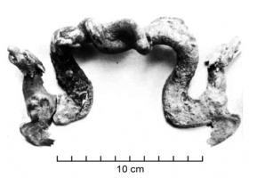BAS-4061 - Bassin : Anse de bassin en forme de dragons
bronze
TPQ : 300 - TAQ : 500
Anse de bassin fixe représentant deux dragons serpentiforme (marins ?) en opposition se retenant par la queue. Revers lisse au niveau de la fixation.