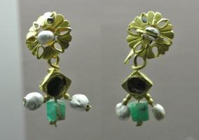 BCO-4024 - Boucle d'oreille
or, pierre
Boucle constituée d'un fil à extrémité effilée, formant une boucle destinée à être passée dans un lobe d'oreille perforé, d'un élément formant le cadre (circulaire ou quadrangulaire) d'une pierre, maintenue sur un axe transversal, puis de trois pendants composés d'e pierres ou de perles enfilées sur des fils d'or.