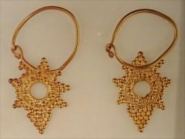 BCO-5010 - Boucle d'oreille en forme d'étoile, granulations
or
Boucle constituée d'un anneau filiforme, fermeture à crochet, auquel se rattache un pendant généralement évidé, constitué de granulations formant un motif radiant (croix, étoile...)