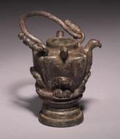 BLS-4024 - Balsamaire à reliefs
bronze
TPQ : 150 - TAQ : 300
Balsamaire coulé ; le corps est constitué de 4 aigles debout, ailes légèrement déployées ; une anse libre joue sur deux anneaux coulés avec le corps du vase ; pied coulé et mouluré.