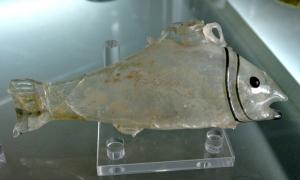 BLS-4072 - Balsamaire : poisson
verre
TPQ : 200 - TAQ : 300
Balsamaire en forme de poisson, le queue suggérée par un écrasement à la pince, la tête (ouïes, yeux et bouche) soulignée par des filets rapportés; au sommet de l\'objet, col avec embouchure étroite.