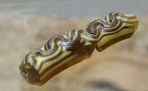 BRC-3037 - Bracelet Geb. 9
verre
TPQ : -150 - TAQ : -125
Bracelet à jonc simple, section en D, en verre brun, orné de filets parallèles rapportés en verre jaune opaque, la zone externe étant ensuite repliée en méandres serrés pour former un motif serpentiforme.