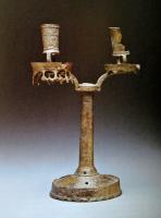 CHL-7003 - Chandelier à deux bobèches
bronze
Chandelier à socle tronconique évasé, surmonté d'une collerette divergente, tige de section circulaire terminée par deux bobèches cylindriques à fente latérale pour le réglage de la bougie.