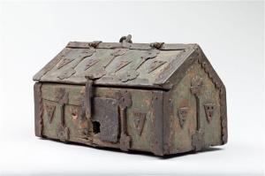 COF-7004 - Coffret en bâtière 
bois, fer
Coffret parallélépipédique à toit taluté. Son couvercle est en bâtière articulé en demi pente. Sa forme est celle d'une chasse. Ferrures interrompues par des fleurons sur toute les faces et cornières en renfort des angles. Un anneau sommital permet sa préhension. Serrure à moraillon.