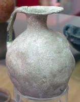 CRU-1001 - Cruche
plomb
Cruche à panse renflée, col étroit, lèvre déformée à l'opposé d'une anse plate.