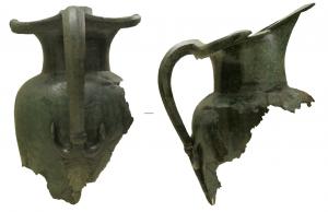 CRU-2011 - Cruche de type Schnabelkanne
bronze
Œnochoé à panse tronconique, épaule marquée et séparée du col, d'abord cylindrique puis évasé, par un angle droit. L'embouchure, oblique, se caractérise par un bec allongé (