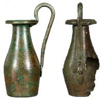 CRU-3015 - Cruche fusiforme à anse surélevée
bronze
Cruche ou olpè à panse renflée dans la partie inférieur (profil biconique), haut col tronconique et embouchure circulaire marquée par une lèvre moulurée; anse surélevée à attache inférieure souvent à décor végétal.