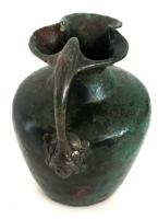 CRU-4112 - Cruche
bronze
Cruche martelée, à épaule marquée mais oblique, col tronconique terminé par un bec bilobé. Anse coulée, dont le sommet élargi vient recouvrir le bord, avec deux bras latéraux épousant l'ouverture; attache inférieure figurative.