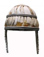 CSQ-1016 - Casque
ivoire, bronze
Casque formé de deux niveaux de défenses de sangliers taillées, percées et cousues sur une base en cuir, le tout cerclé de trois rangs d'anneaux doubles en bronze ; longs protège-joues.