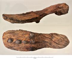 CSS-4004 - Chaussure à semelle de bois, socque
bois, cuir, fer
Chaussure (ou socque) comportant une semelle rigide en bois, souvent pourvue d'un talon nettement distinct, et d'une partie en cuir qui peut être clouée sur les côtés de la semelle par une série de clous en fer, ou rattachée à la semelle entre les deux plus gros orteils. D'autres clous peuvent protéger la partie inférieure de la