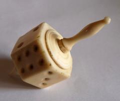 DEJ-9014 - Dé-toupie
os
Dé hexagonal en forme de toupie, composé d'une partie centrale creuse, hexagonale, portant des chiffres (1-6) indiqués par des ponctuations; bouchons tournés et moulurés, prolongés d'un côté par une pointe de rotation, de l'autre par un tenon permettant de lancer la toupie.