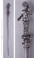 EPG-4501 - Épingle : Vénus
argent
TPQ : 1 - TAQ : 400
Epingle dont le sommet reproduit une figurine de Vénus, posée sur un petit chapiteau corinthien : la déesse sort du bain, la main gauche tordant une mèche de cheveux, la main droite tendue vers l'avant retenant un pan du vêtement noué sur le bas du corps, qui glisse de la taille.
