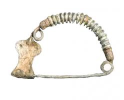 FIB-2667 - Fibule arquée
bronze
Fibule à arc en demi-cercle, légèrement renflé vers le haut. Une série de stries transversales ou anneaux serrés servent de décor. Ressort unilatéral à une spire ; porte-ardillon aplati, de forme rectangulaire, étranglé à mi-hauteur.