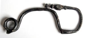 FIB-3848 - Fibule laténienne à pied redressé
fer
TPQ : -400 - TAQ : -200
Fibule de schéma laténien, à corps filiforme en anse de panier; ressort bilatéral court à 4 spires et corde externe; pied redressé vers l'arc et terminé par  des moulures évoquant une tête d'oiseau.