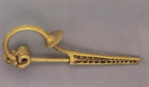 FIB-3906 - Fibule de type Kragenfibel
or
TPQ : -75 - TAQ : -40
Fibule composite, à corde externe, griffe et plaquettes, arc le plus souvent triangulaire (parfois à angles adoucis) interrompu par un disque perpendiculaire serti, pied allongé et porte-ardillon allongé.