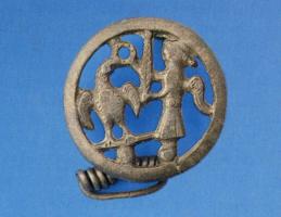 FIB-41024 - Fibule : aigle et Victoire
bronze
TPQ : 150 - TAQ : 250
Fibule représentant une scène figurée dans un cadre circulaire, les motifs sont plats et ajourés : la Victoire couronnant une aigle aux ailes déployées, à laquelle elle remet la palme victorieuse. Au revers, long ressort sur axe et plaquette unique, et porte-ardillon en bande rectangulaire encochée.