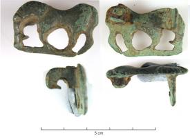 FIB-41300 - Fibule zoomorphe : cheval
bronze
TPQ : 100 - TAQ : 250
Fibule zoomorphe en forme de cheval à gauche, barre entre les 4 pattes figurées, tête baissée, corps lisse; la crinière est indiquée par des incisions parallèles.