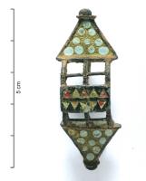 FIB-41351 - Fibule symétrique émaillée
bronze
TPQ : 75 - TAQ : 125
Fibule symétrique, à décor émaillé ; le corps central de forme rectangulaire est creusé de deux rangées adossées de triangles émaillés ; il sépare deux parties symétriques forés d'un ajour fenestré, suivi de terminaisons triangulaires ornées d'un semis de pastille de verre prises dans l'émail, et terminées par des boutons..