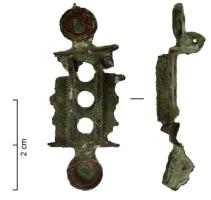 FIB-41469 - Fibule symétrique émaillée
bronze
TPQ : 100 - TAQ : 250
Fibule symétrique, au corps rectangulaire perforé d'une série de 3 ajours circulaires bordé de 2 plaquettes rectangulaires de champ, avec les mêmes décors de 2 ajours circulaires accostés d'un disque sur les côtés ; aux extrémités pied et tête, pastilles ou disques émaillés.