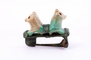 FIB-41690 - Fibule léontomorphe
bronze, os
TPQ : 1 - TAQ : 50
Fibule à charnière, arc remplacé par deux protomés de lions adossés, en os et posant les pattes antérieures sur des barrettes fixées sur la plaque-support ; charnière tubulaire repliée vers l'intérieur.