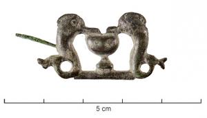 FIB-41720 - Fibule zoomorphe, groupe : dauphins et vase
bronze
TPQ : 40 - TAQ : 90
Fibule composée d'un vase à pied encadré de deux dauphins, le museau posé sur le bord du vase; trait de sol.