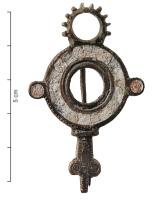 FIB-41947 - Fibule émaillée
bronze
TPQ : 140 - TAQ : 260
Fibule asymétrique, à arc en forme de couronne émaillée, encadrée de deux disques également émaillés ; à la tête, une couronne crenelée ; le pied est formé d'une tête de reptile stylisées, à décor d'écailles gravées. Au revers, charnière entre deux plaquettes coulées.