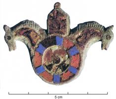 FIB-4217 - Fibule émailléebronzeTPQ : 150 - TAQ : 300Fibule composée d'un disque émaillée de deux couronnes autour d'un disque central, accosté de deux têtes de chevaux divergentes, avec émaux sur l'encolure et crinière incisée; au centre, façade ou char (?), également émaillé.