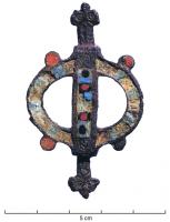 FIB-4218 - Fibule symétrique émailléebronzeTPQ : 150 - TAQ : 300Fibule composée d'une couronne émaillée, avec 4 disques émaillés sur le pourtour, traversée par une bande axiale également émaillée; terminaisons symétriques en têtes de reptiles.