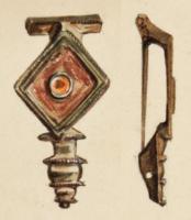 FIB-4538 - Fibule émaillée 
bronze
TPQ : 100 - TAQ : 150
Fibule à corps losangique, creusé d'une loge d'émail autour d'un disque central lui aussi émaillé; le pied se termine par une série de moulures. Des protubérances latérales circulaires et émaillées décorent certains exemplaires