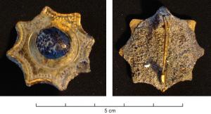 FIB-4670 - Fibule à décor rayonnant et cabochon
bronze
TPQ : 75 - TAQ : 350
Broche rayonnante à huit pointes séparées par des segments concaves; placage avec décor perlé enserrant un cabochon central bombé, en verre bleu.