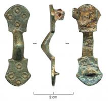 FIB-5020 - Fibule symétrique anséebronzeTPQ : 600 - TAQ : 720Fibule ansée composée de deux appendices symétriques élargis aux extrémités scutiformes, autour d'un arc formant un arc épaissi, avec ou sans table sommitale ; décor de cercles oculés.