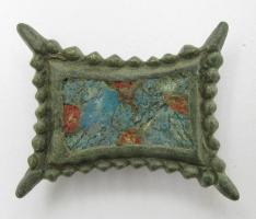 FIB-6003 - Fibule rectangulaire émailléebronzeTPQ : 800 - TAQ : 950Fibule plate rectangulaire à bords concaves dentelés. La partie centrale est entièrement émaillée, et parsemée de 5 petites loges circulaires