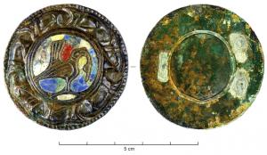 FIB-6016 - Fibule circulaire émailléebronzeTPQ : 950 - TAQ : 1050Fibule circulaire, en léger relief sur la face supérieure, plate et lisse en dessous (la fixation du ressort et le porte-ardillon étaient rapportés). Autour d'un fleuron central figurant un animal en réserve, entouré d'émail, une couronne externe comporte une frise d'animaux ou de protomés de monstres.