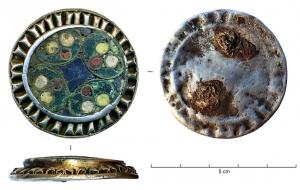 FIB-6039 - Fibule circulaire émailléeargentTPQ : 950 - TAQ : 1050Fibule circulaire constituée de deux étages de décors : un disque plat (auquel étaient soudés la fixation du ressort et le porte-ardillon) est orné d'une couronne constituée d'un ruban de fine tôle d'argent plissée ; un second disque central, également en argent, porte un décor cloisonné par des fils d'alliage cuivreux : 4 pétales en arcs de cercles, en verres polychromes, autour d'un motif central carré à côtés concaves, en verre coloré.
